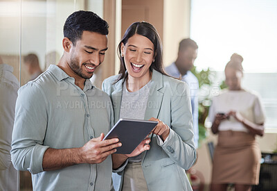 Buy stock photo Shot of two coworkers talking while using a digital tablet