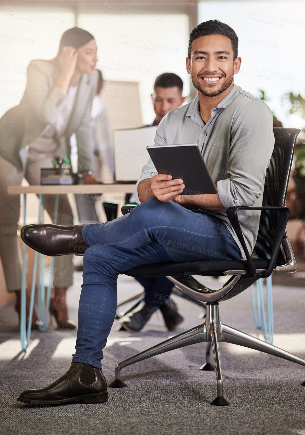 Buy stock photo Shot of a young businessman using his digital tablet