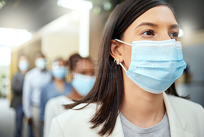 Buy stock photo Cropped shot of an attractive young businesswoman wearing a mask while standing at the head of a queue in her office