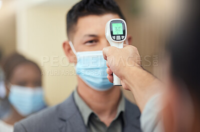 Buy stock photo Cropped shot of a handsome mature businessman wearing a mask and having his temperature taken while standing at the head of a queue in his office