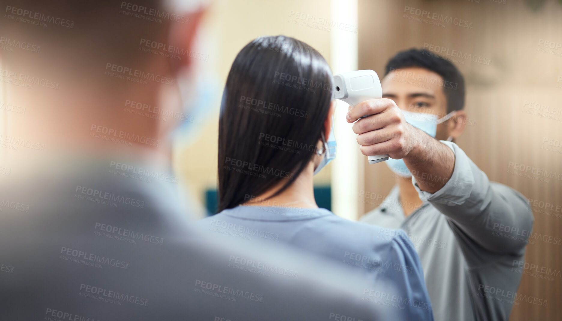 Buy stock photo Cropped shot of an unrecognizable businesswoman wearing a mask and having her temperature taken while standing at the head of a queue in her office