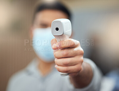 Buy stock photo Cropped shot of an unrecognizable man ready to take your temperature using a digital thermometer in the workplace