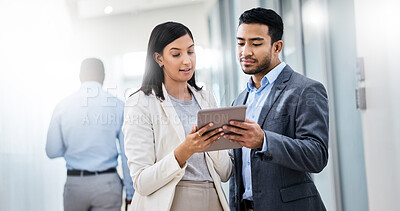 Buy stock photo Shot of two businesspeople discussing something on a digital tablet