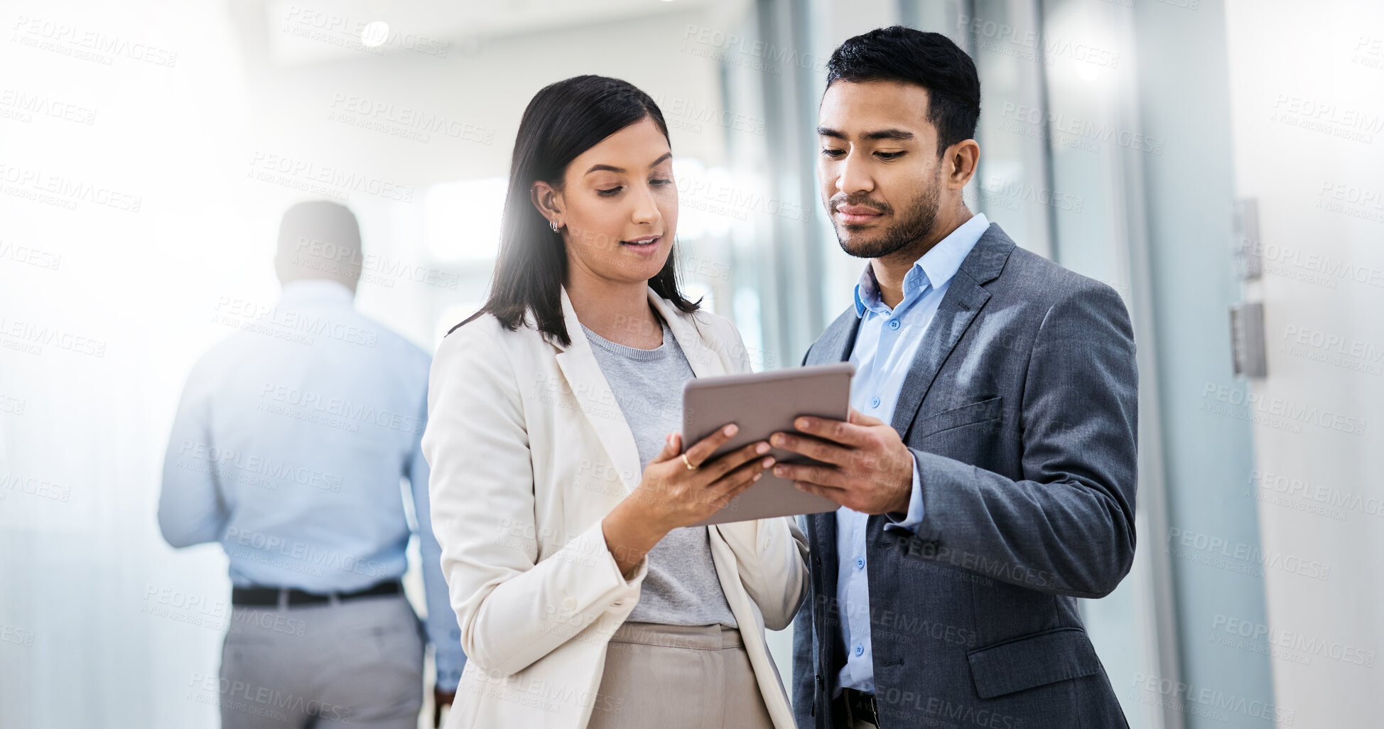 Buy stock photo Shot of two businesspeople discussing something on a digital tablet