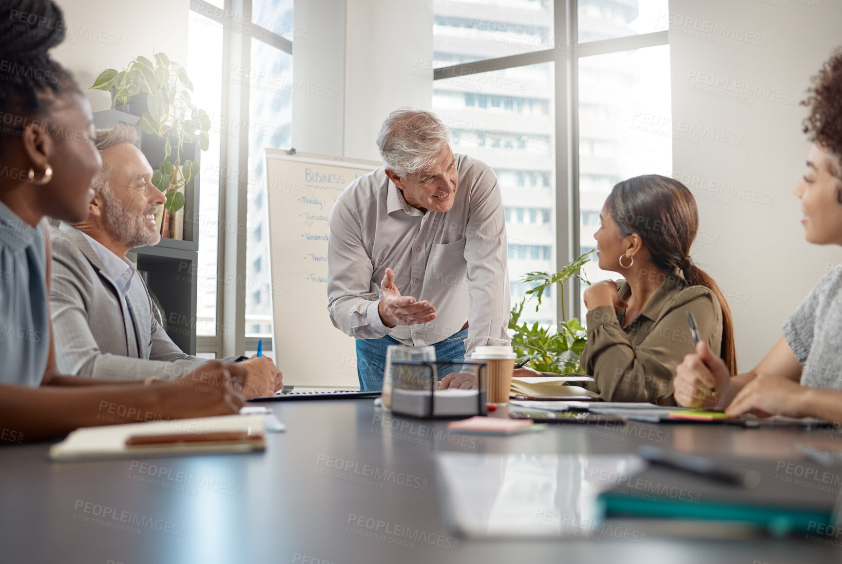 Buy stock photo Shot of a mature businessman talking in a meeting at work