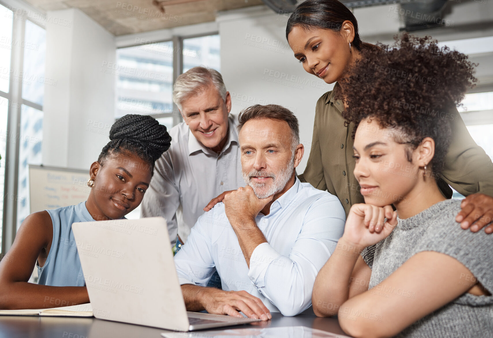 Buy stock photo Shot of a group of businesspeople using a laptop at work