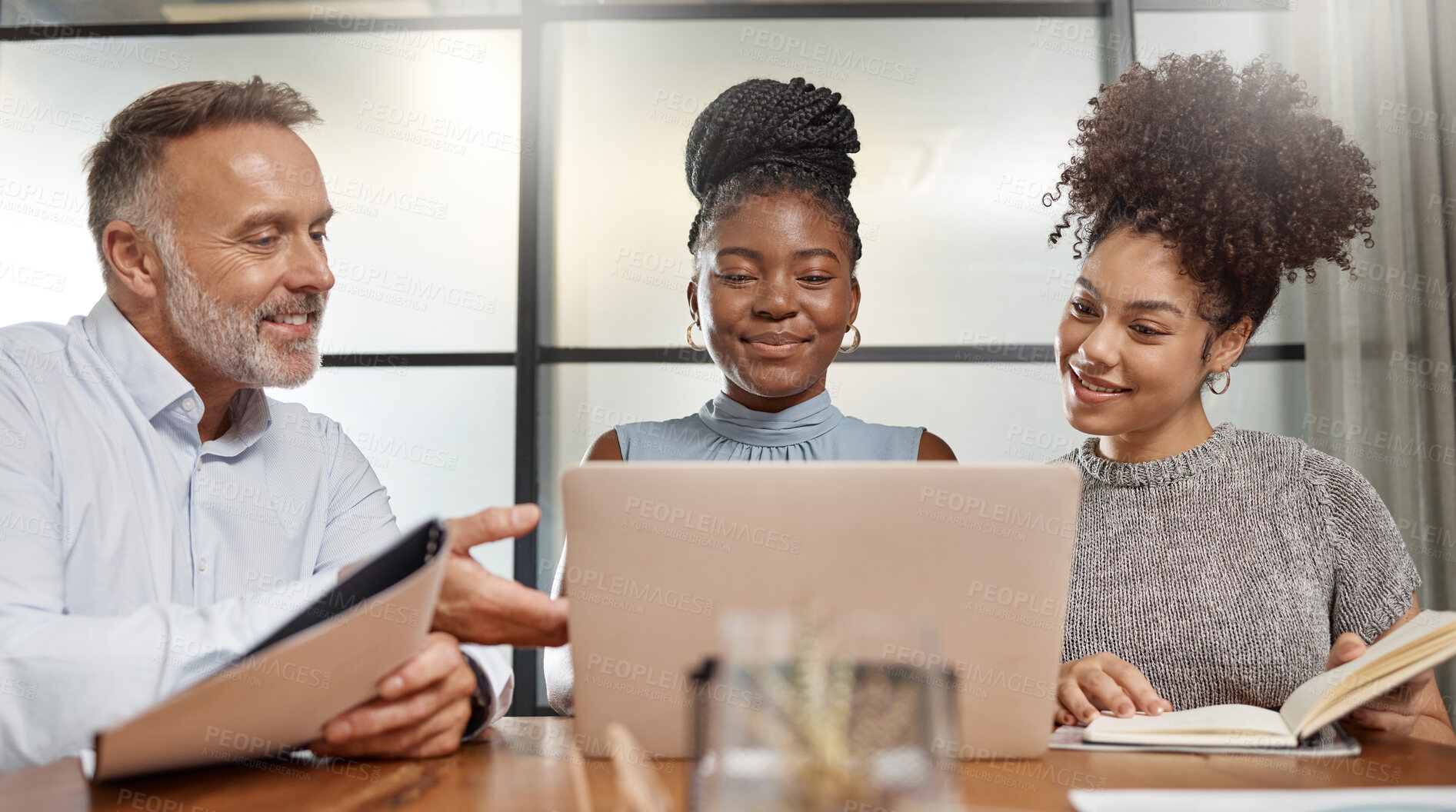 Buy stock photo Shot of a group of businesspeople using a laptop at work