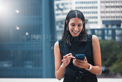 Buy stock photo Cropped shot of an attractive young businesswoman sending a text while standing outside on the office balcony