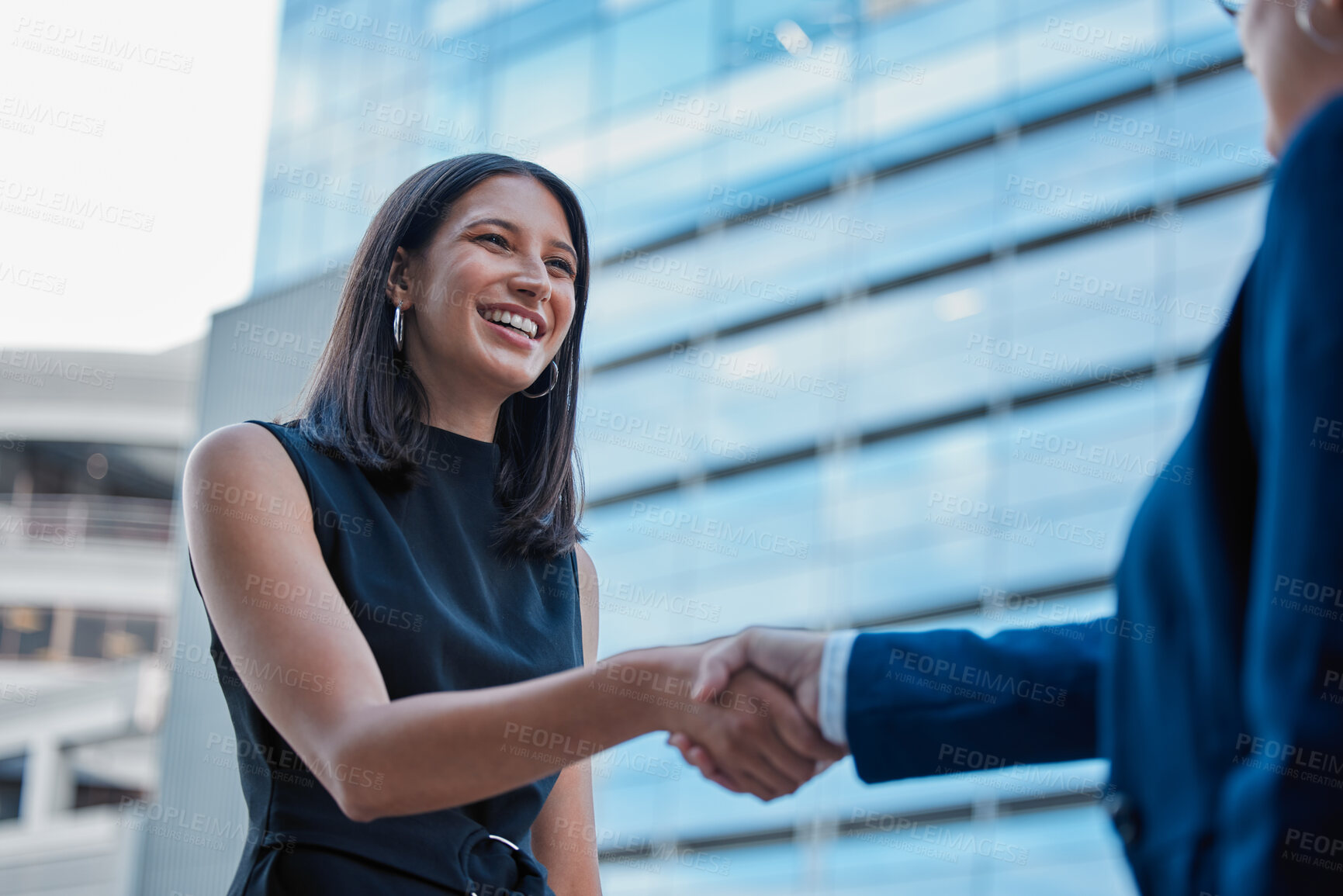 Buy stock photo Cropped shot of an attractive young businesswoman shaking hands with an unrecognizable businessman outside on the office balcony