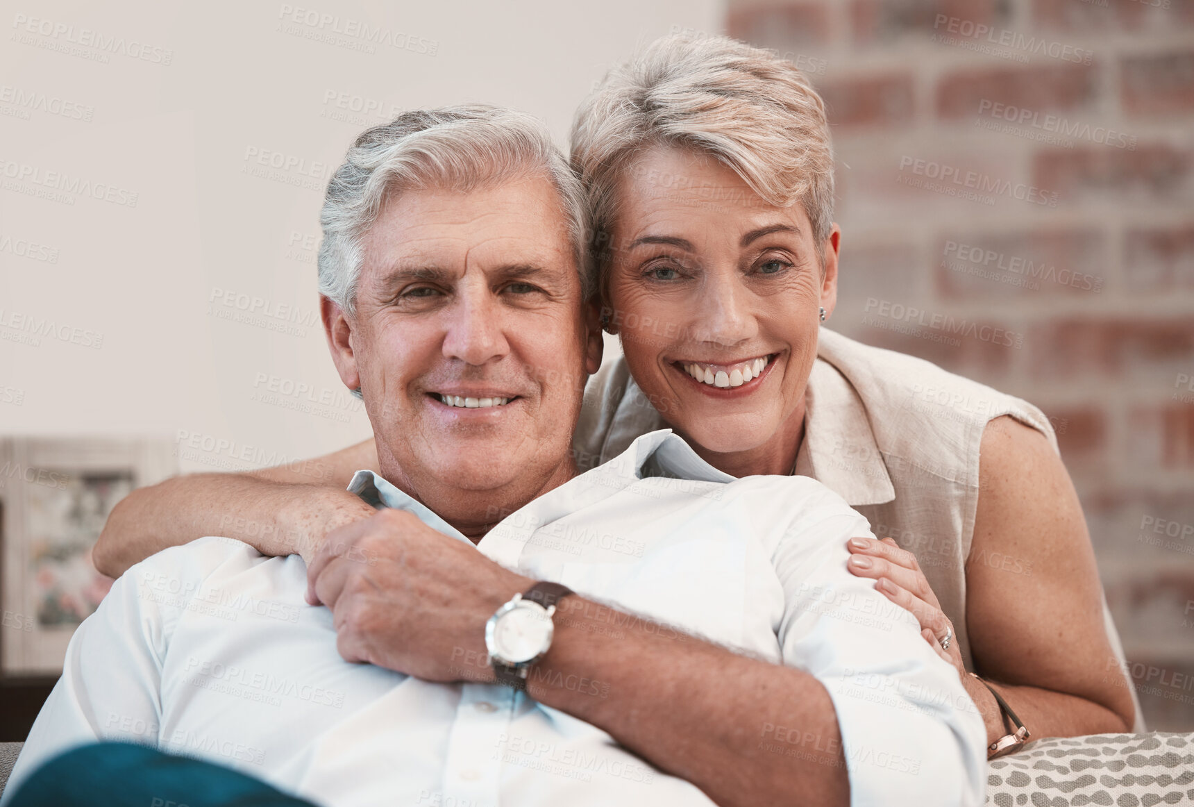 Buy stock photo Portrait of an affection mature couple posing for a picture on the sofa together at home