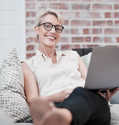 Buy stock photo Portrait on an older woman using a laptop and looking relaxed on the sofa at home