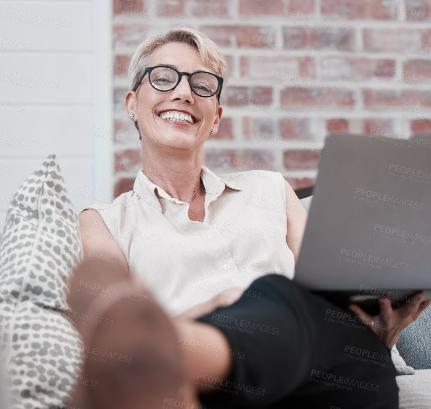 Buy stock photo Laptop, portrait and smile with mature woman on sofa in living room of home for remote work. Computer, glasses and online with happy employee in apartment for freelance job, occupation or research