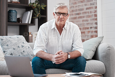 Buy stock photo Portrait of an older man using his laptop while sitting on the couch at home