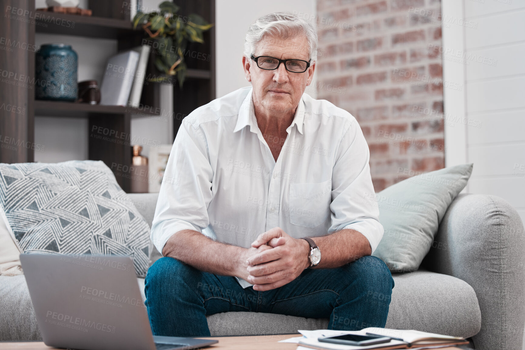 Buy stock photo Portrait of an older man using his laptop while sitting on the couch at home