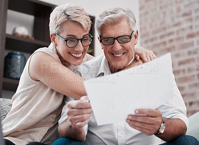 Buy stock photo Shot of a mature couple going through paperwork on the sofa at home together