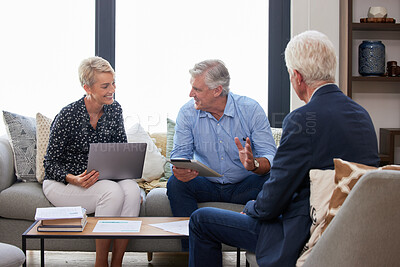 Buy stock photo Shot of a group of businesspeople going through paperwork