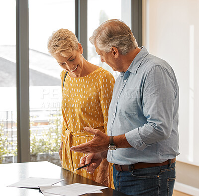 Buy stock photo Shot of a senior male realtor going through paperwork with a client