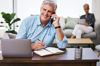 Buy stock photo Shot of a mature man making notes while talking on his cellphone