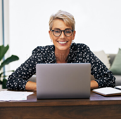 Buy stock photo Shot of a mature woman using her laptop while working from home