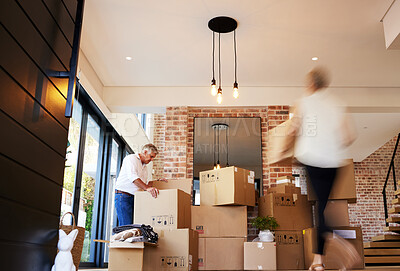Buy stock photo Shot of a mature couple unpacking boxes on moving day