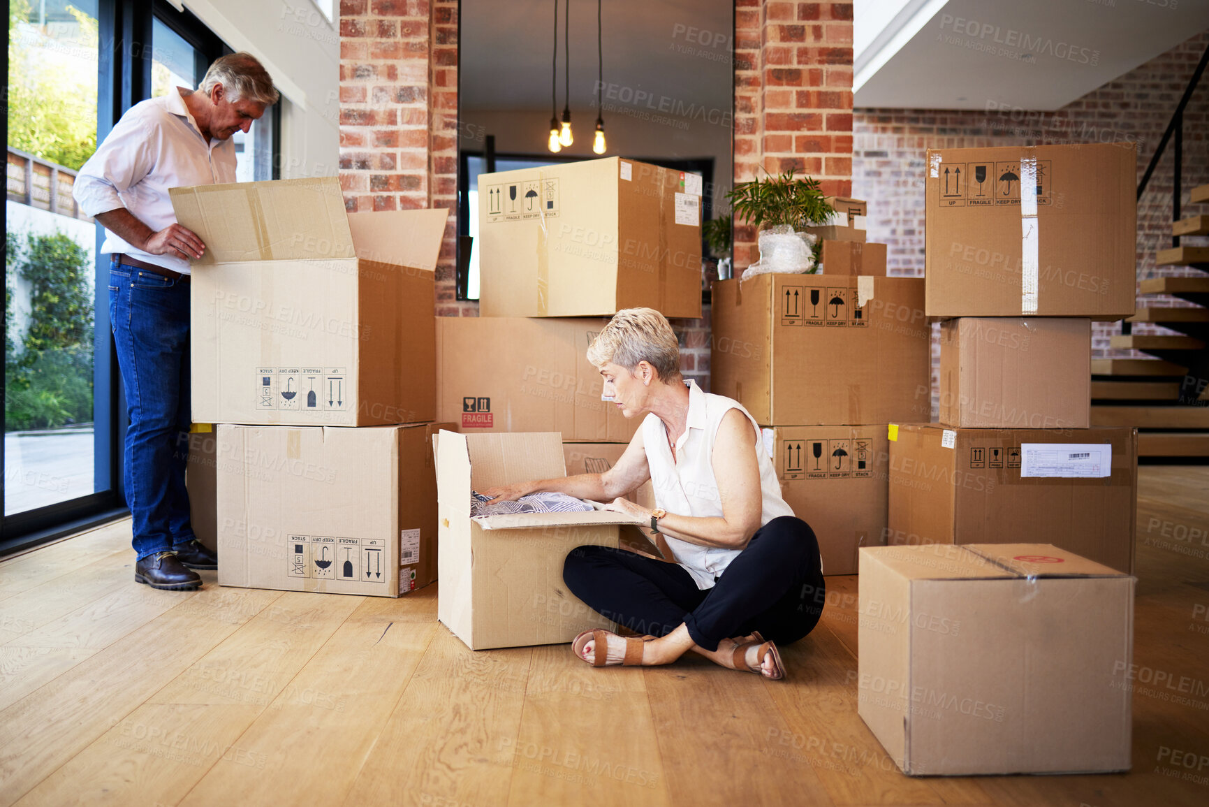 Buy stock photo Boxes, moving and senior couple at new house for unpacking in living room for homeownership. Love, mortgage and elderly man and woman with cardboard packages in apartment together for retirement.