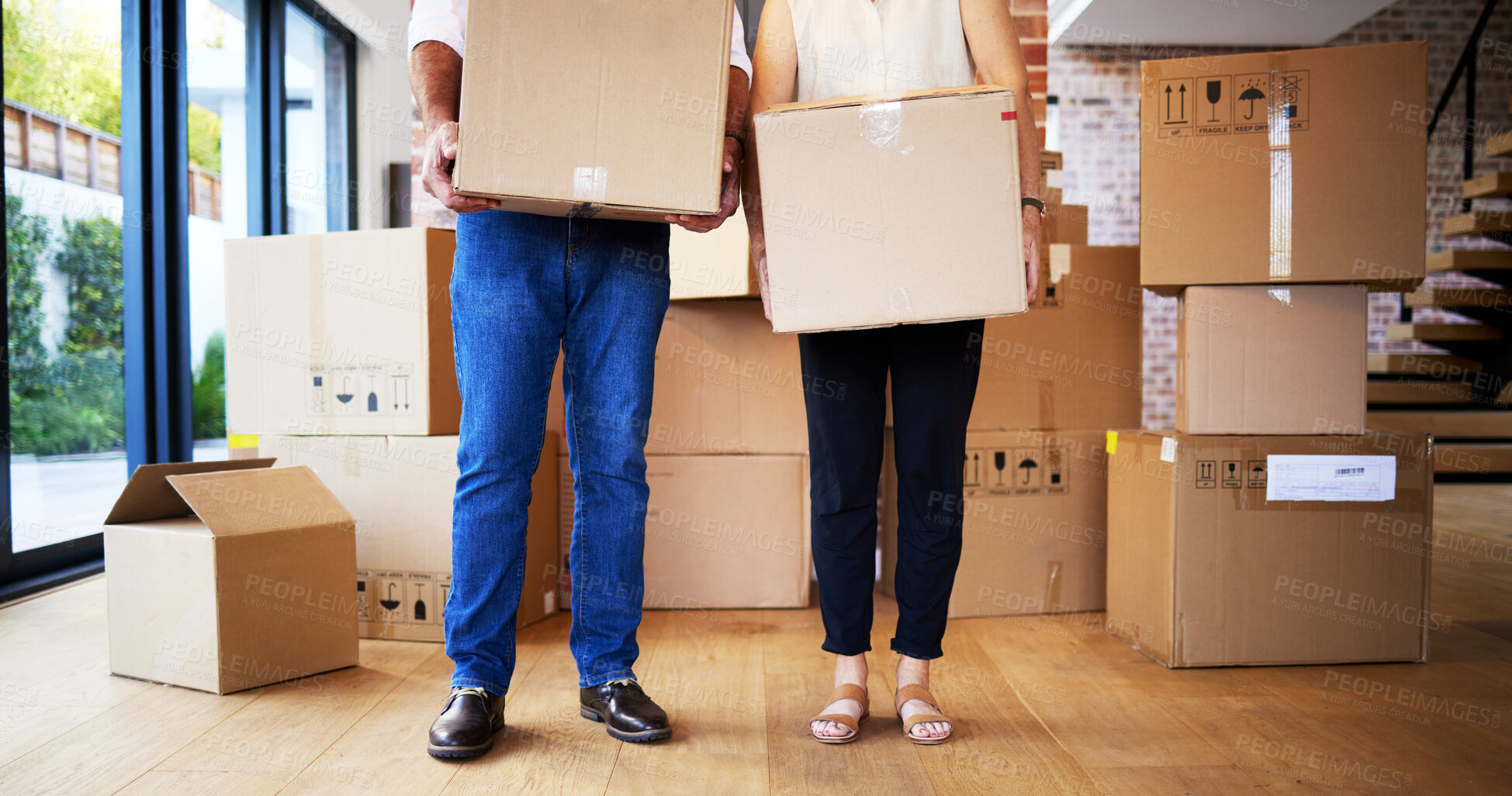 Buy stock photo Shot of an unrecognisable mature couple carrying boxes on moving day