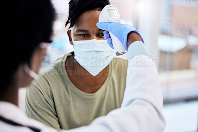 Buy stock photo Cropped shot of a handsome young male patient having his temperature taken by the doctor during a consult