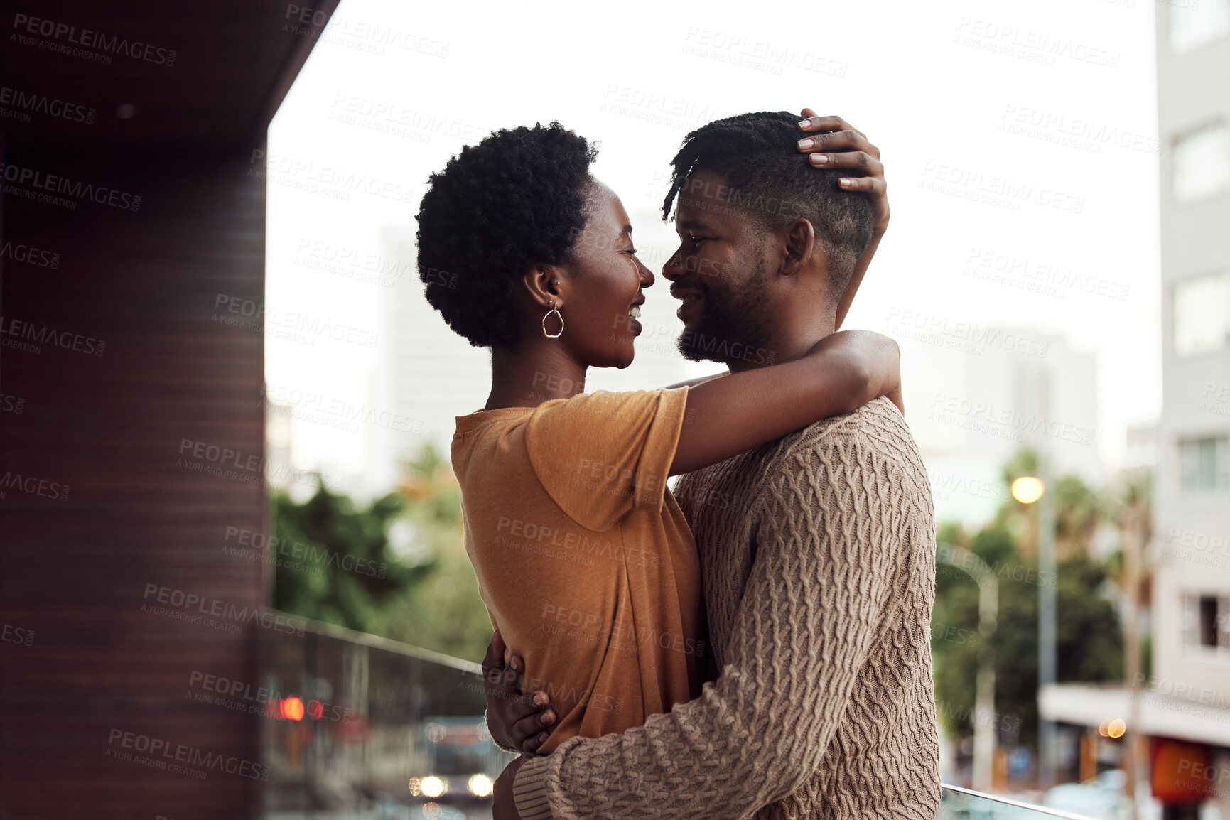 Buy stock photo Shot of an affectionate your couple bonding on a balcony outdoors