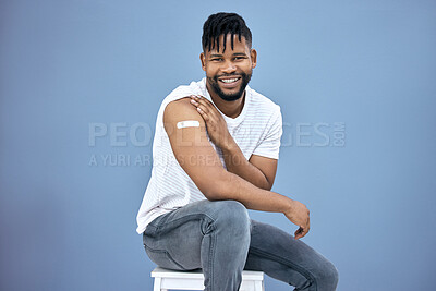 Buy stock photo Shot of a handsome young man sitting alone in the studio after getting his Covid vaccine