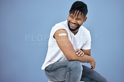 Buy stock photo Vaccine, healthcare and black man with plaster in studio for flu, disease or illness prevention. Smile, wellness and African male person with plaster for medical immunization by gray background.