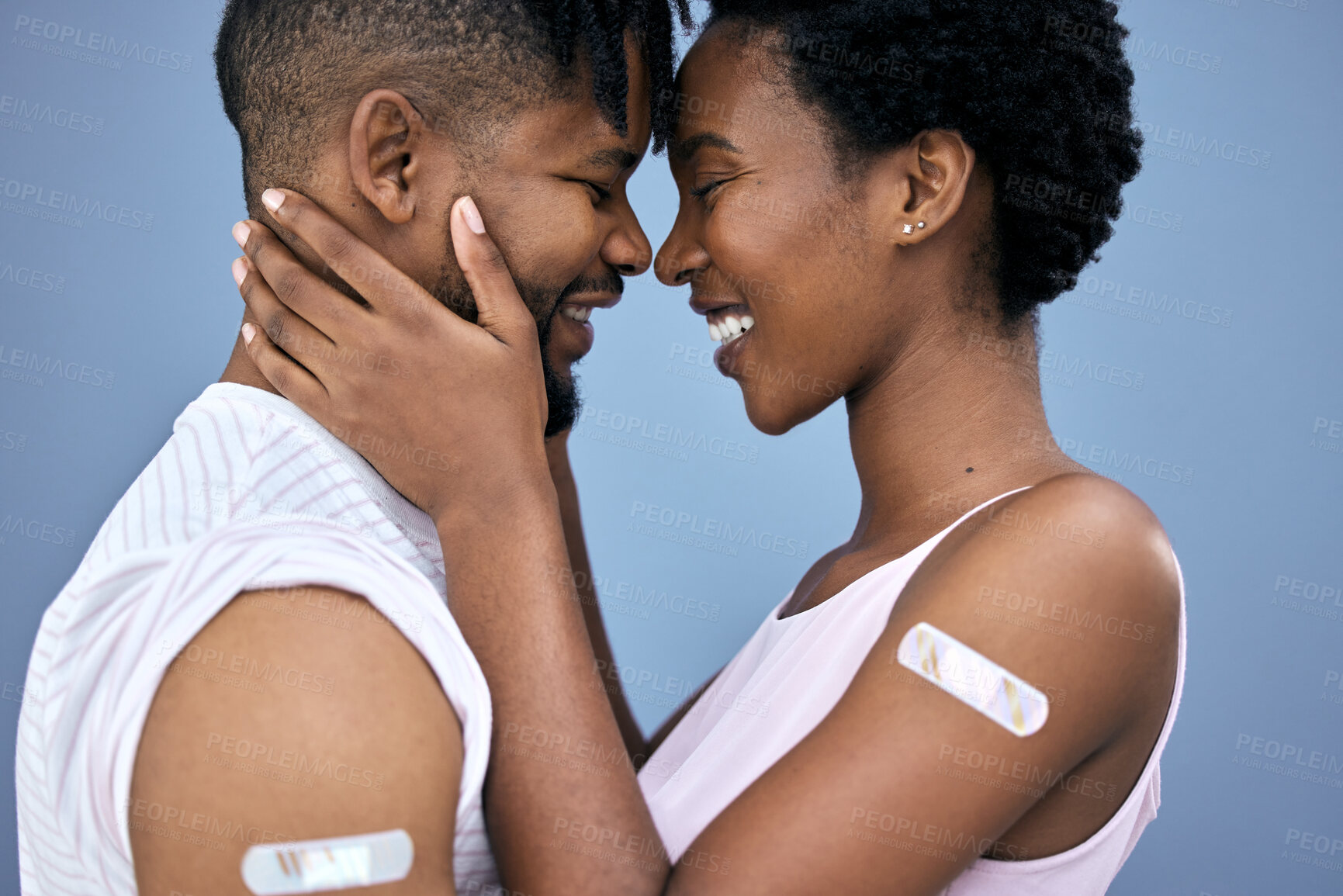 Buy stock photo Shot of a young couple hugging each other in the studio after getting their Covid vaccines