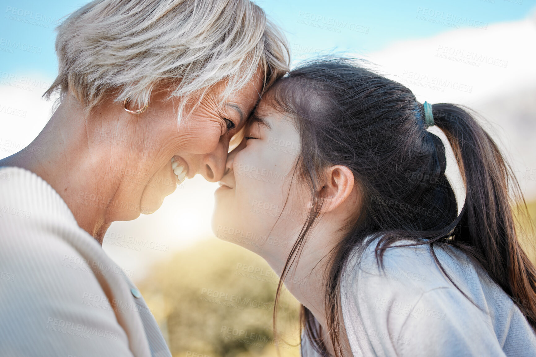 Buy stock photo Shot of a little girl bonding with her grandmother outdoors