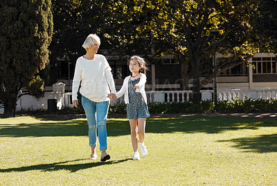 Buy stock photo Shot of a little girl walking with her grandmother in a park