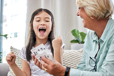 Buy stock photo Grandmother, child and teaching in home for education, development and happy together on couch. Girl, woman and family on sofa with cards for playing cards, laugh and love with smile for weekend 