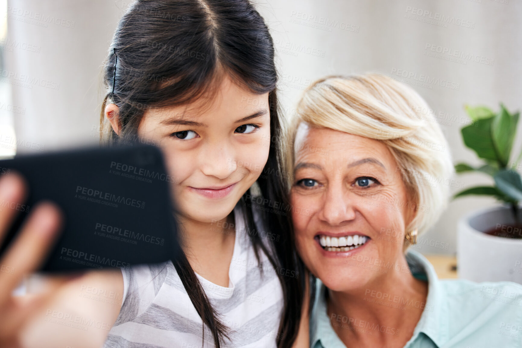 Buy stock photo Grandmother, child and selfie in home for memory, online streaming and happy together on couch. Girl, woman and family on sofa with cellphone for social media, smile and profile picture with love 