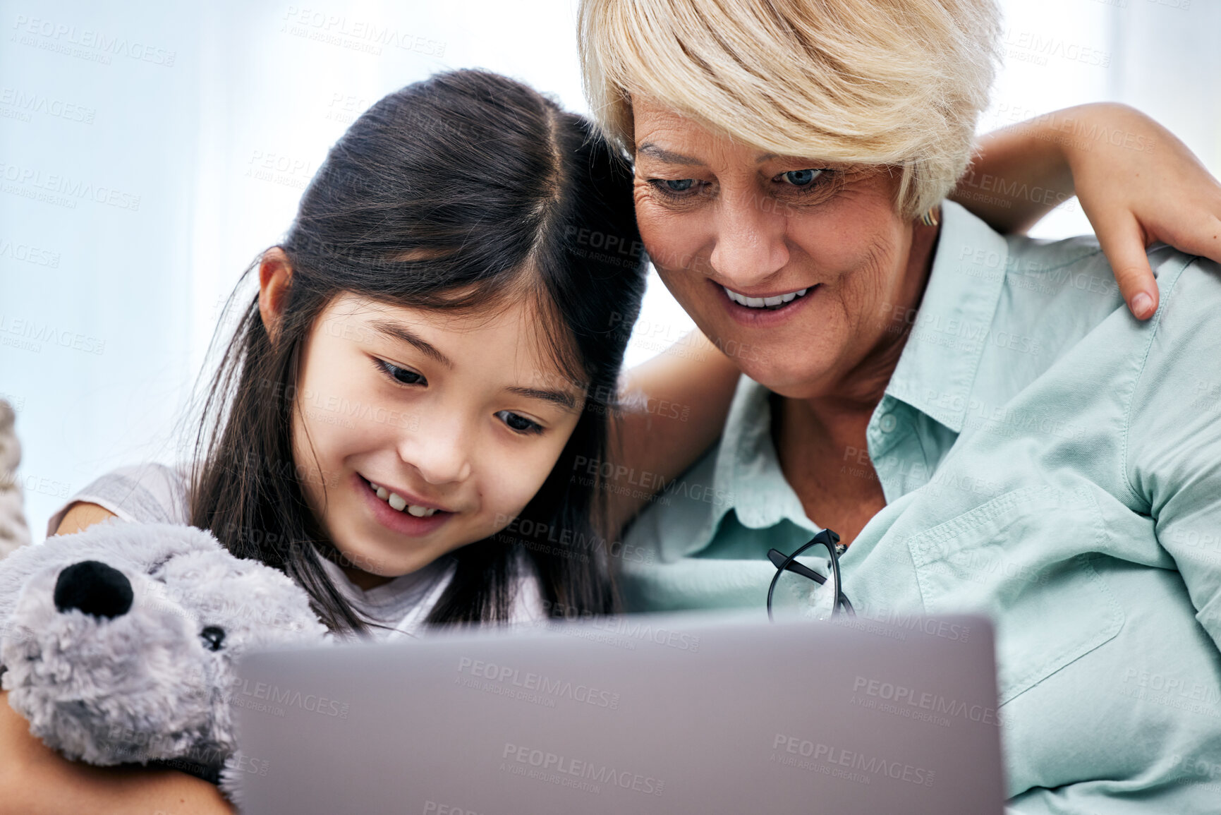 Buy stock photo Happy, tablet and senior woman with child reading ebook for knowledge with teddy bear at home together. Smile, bonding and grandmother relax and enjoying online story with girl kid and toy at house.