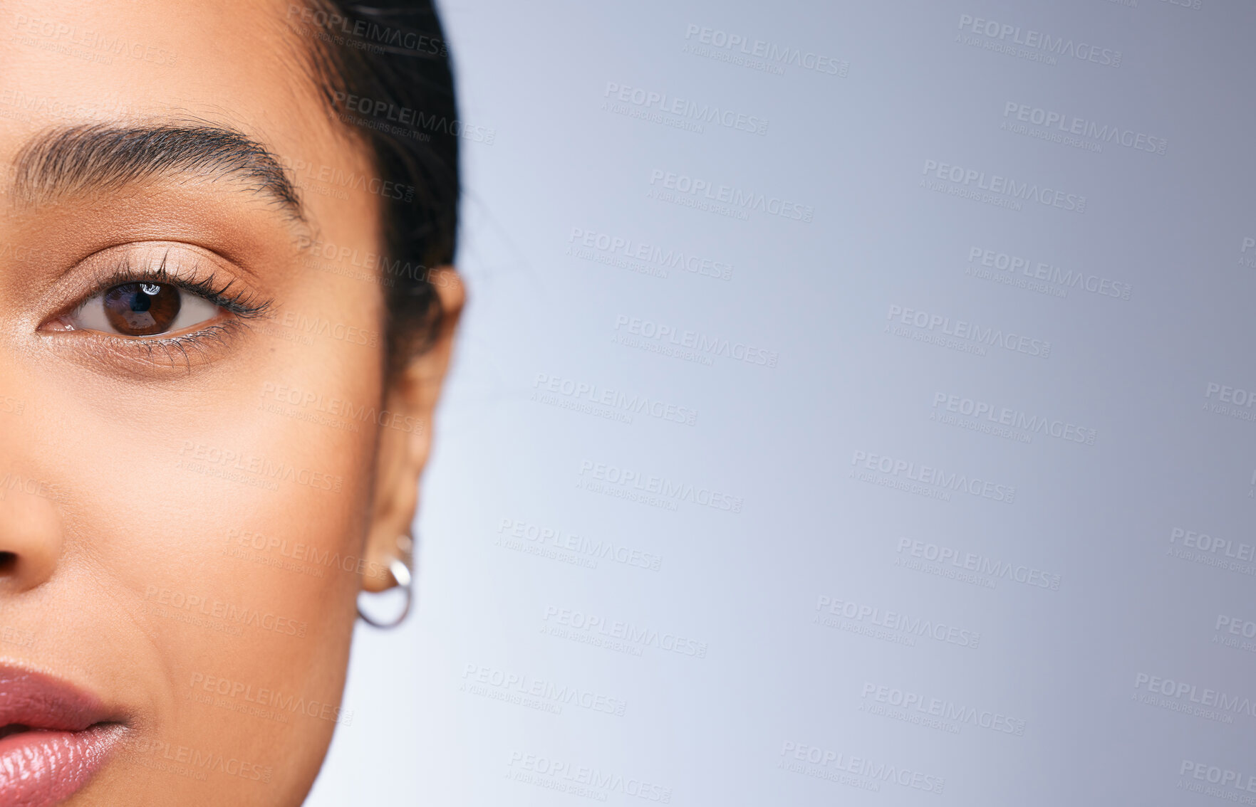 Buy stock photo Cropped portrait of a beautiful young woman posing against a blue background