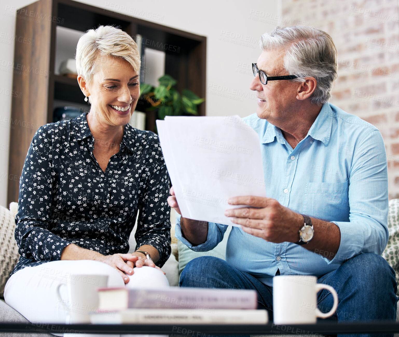 Buy stock photo Shot of a senior male realtor going through paperwork with a client