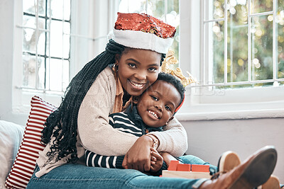 Buy stock photo Shot of a woman sitting at home with her son during Christmas time