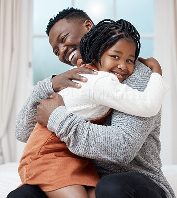 Buy stock photo Shot of a young father hugging his daughter while bonding at home