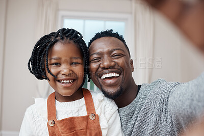 Buy stock photo Shot of a young father bonding with his daughter at home and taking a selfie