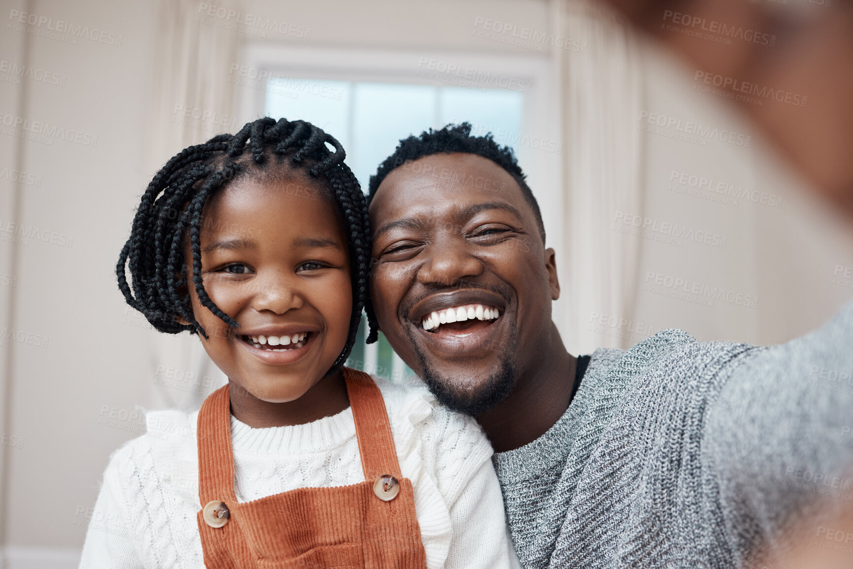 Buy stock photo Shot of a young father bonding with his daughter at home and taking a selfie