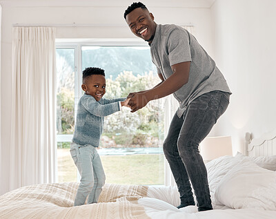 Buy stock photo Full length portrait of an adorable little boy playing with his father on a bed at home