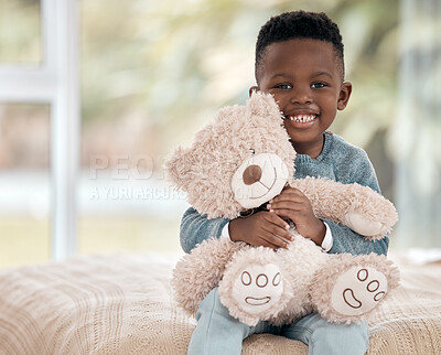 Buy stock photo Cropped portrait of an adorable little boy sitting on a bed at home with his teddy bear