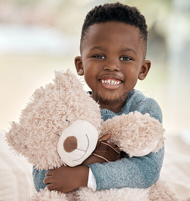 Buy stock photo Cropped portrait of an adorable little boy sitting on a bed at home with his teddy bear