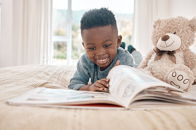 Buy stock photo Young african boy, reading and bed for story, book and learning with smile in family home, focus and excited. Black male child, education and relax in bedroom with happiness, study or comic in house
