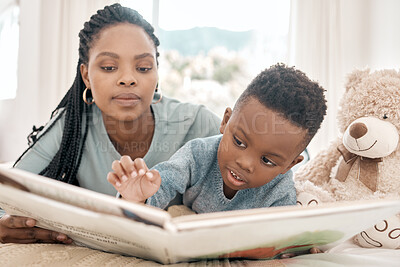 Buy stock photo Cropped shot of an adorable little boy and his mother reading a book on a bed at home