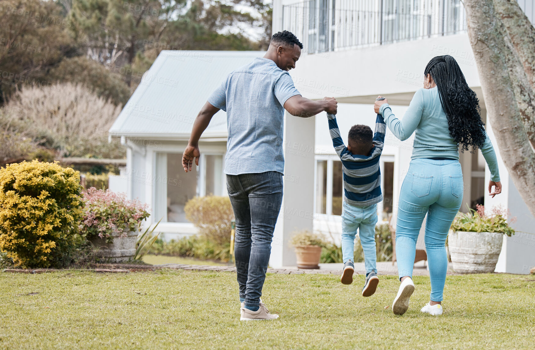 Buy stock photo Mother and father lifting child by their new home in the outdoor garden while playing together. Backyard, bonding and back of African parents holding their boy kid in the backyard of their house.
