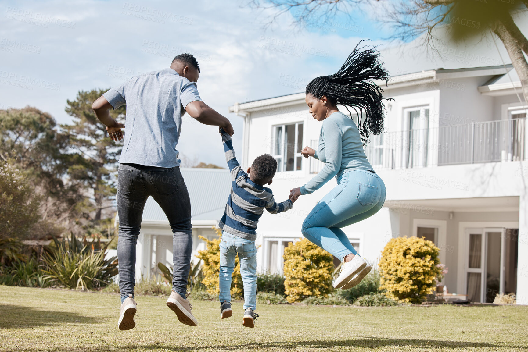 Buy stock photo Full length shot of a young couple bonding with their son in the garden