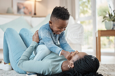 Buy stock photo Shot of a young mother lying on the the living room floor and bonding with her son at home